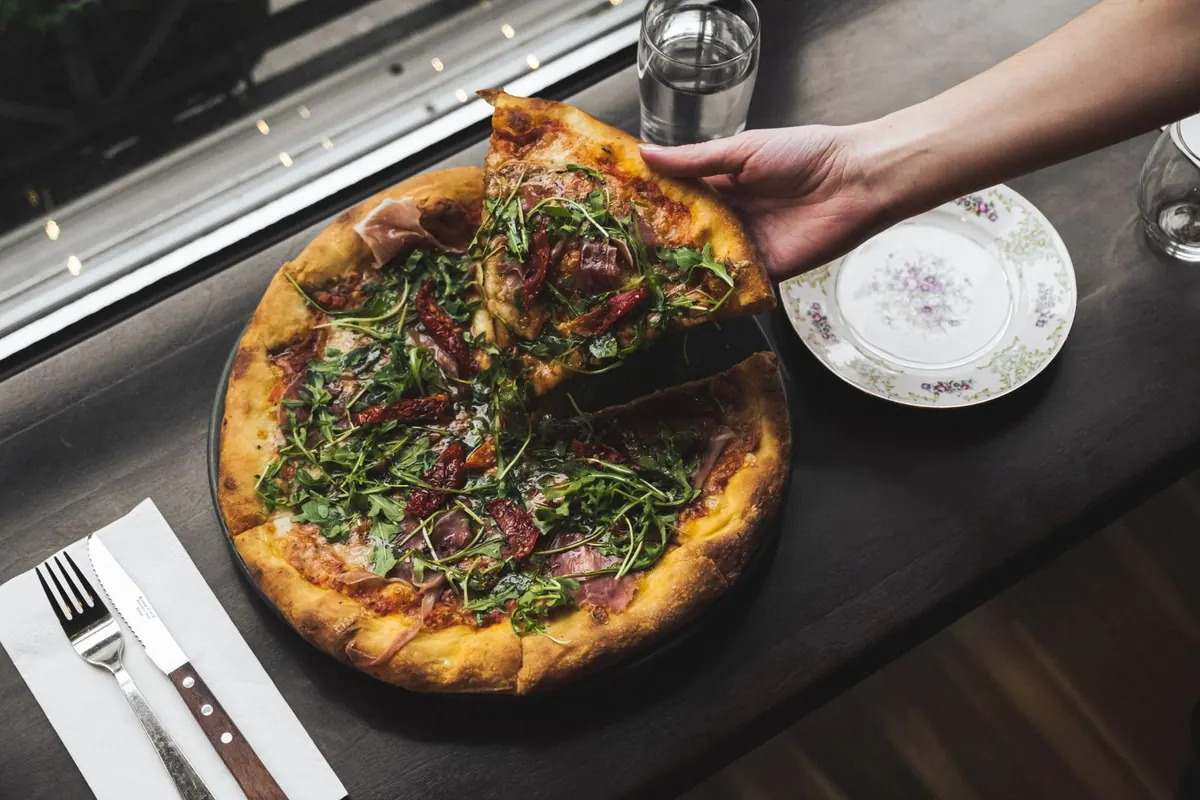 A shared pizza on the table, by the window