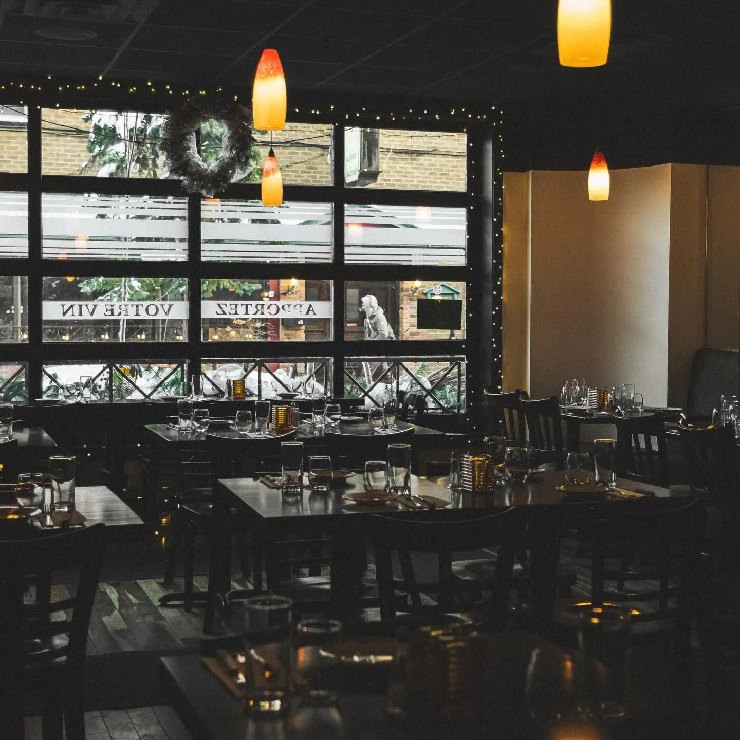 Sorino’s dining room set for a group, lights along the windows