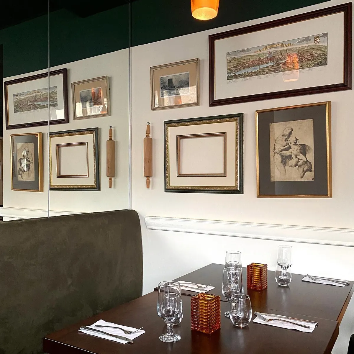 A set booth in the dining room, glasses and frames on the wall